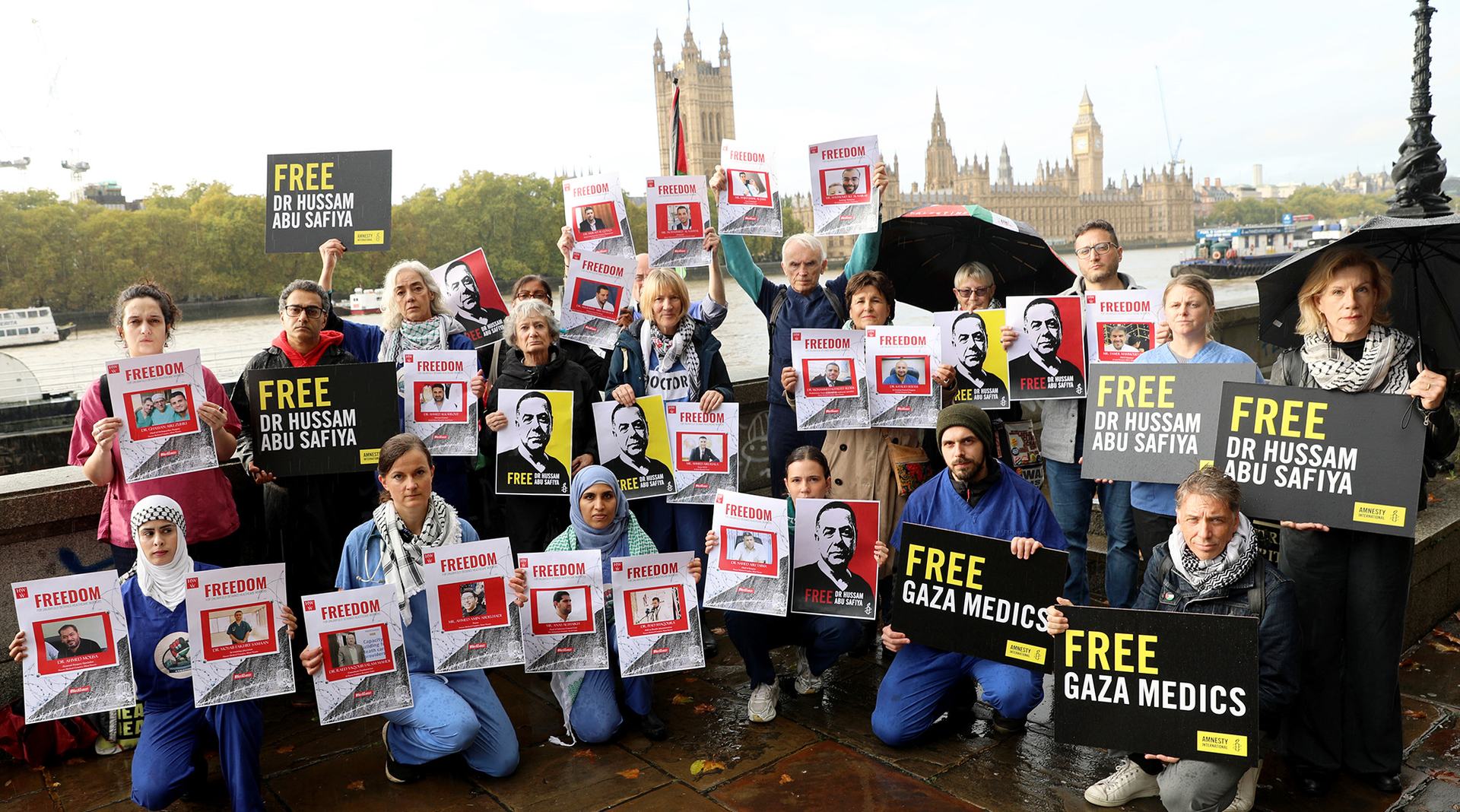 Medics wearing scrubs and activists holding placards reading “Free Gaza Medics”, “Free Dr Hussam Abu Safiya”, “Stop Arming Israel” the protesters stood against the backdrop of Parliament.