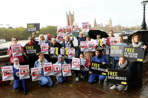 Medics wearing scrubs and activists holding placards reading “Free Gaza Medics”, “Free Dr Hussam Abu Safiya”, “Stop Arming Israel” the protesters stood against the backdrop of Parliament.