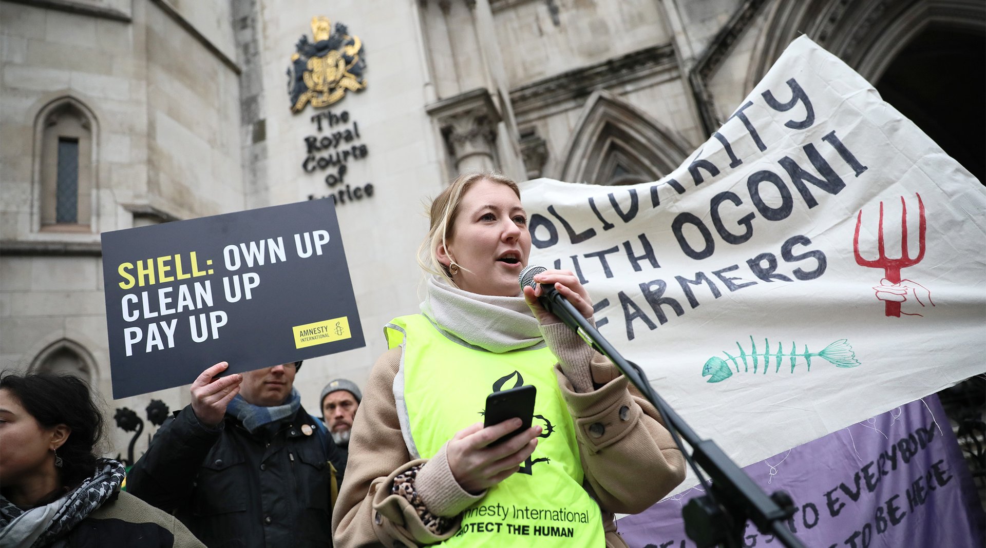 Amnesty International UK protesters hold a placard that says 'RESIST RACISM'