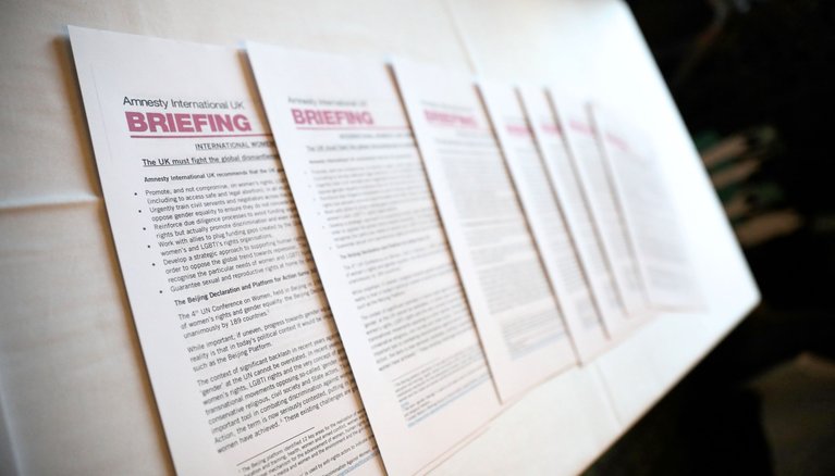 Amnesty International Briefing papers laid out on a table