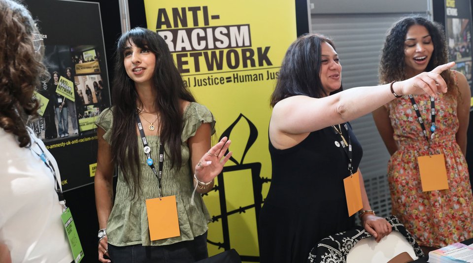 Activists standing in front of a banner welcoming new members to the Anti-racism network