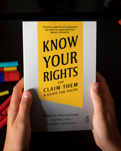 Image of someone's hands holding the "Know your Rights and Claim Them"