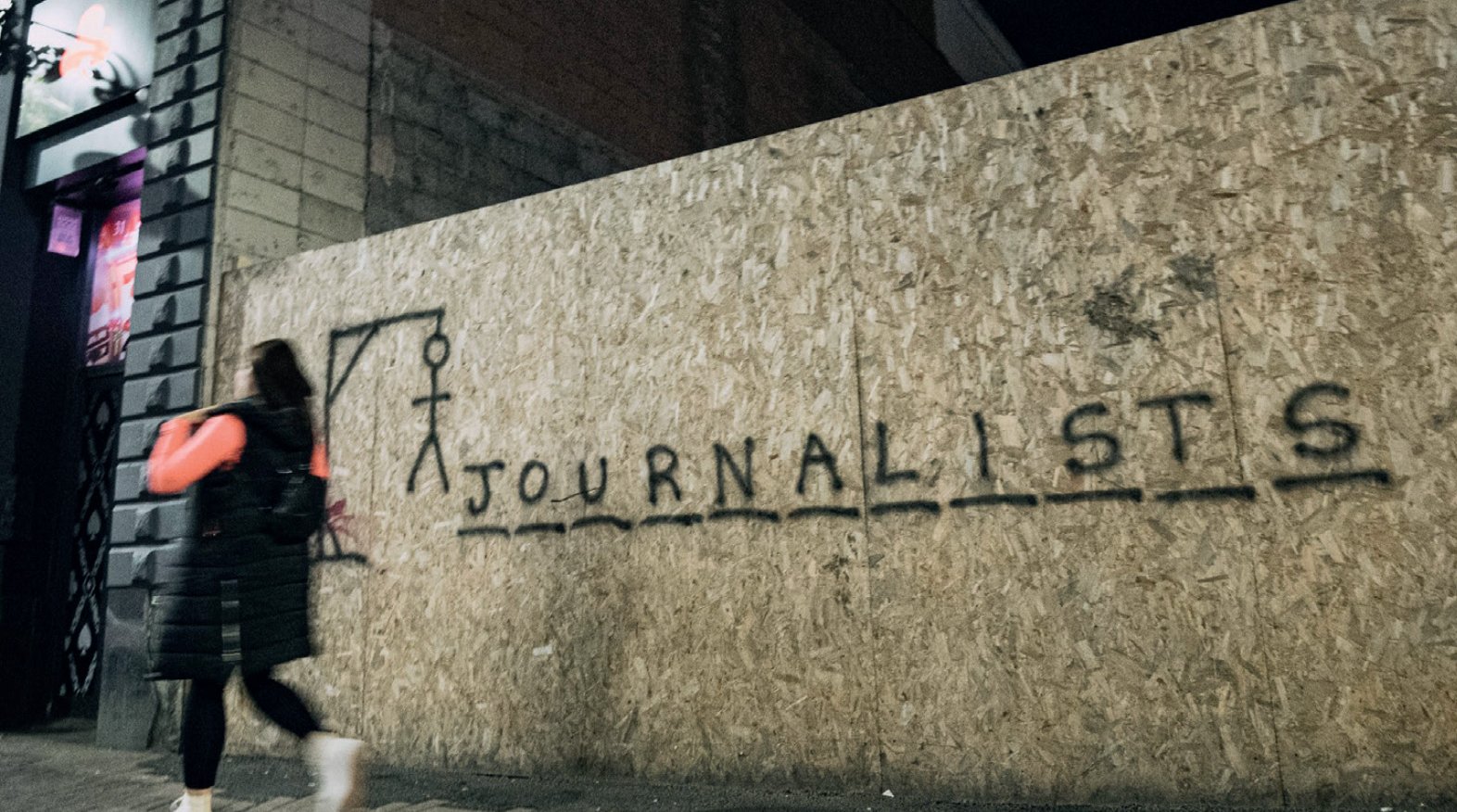 Graffiti on a wall in the style of hangman game spells out 'Journalists'