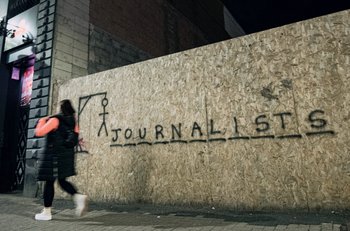 Graffiti on a wall in the style of hangman game spells out 'Journalists'