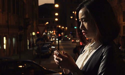 Scared woman looking at her phone