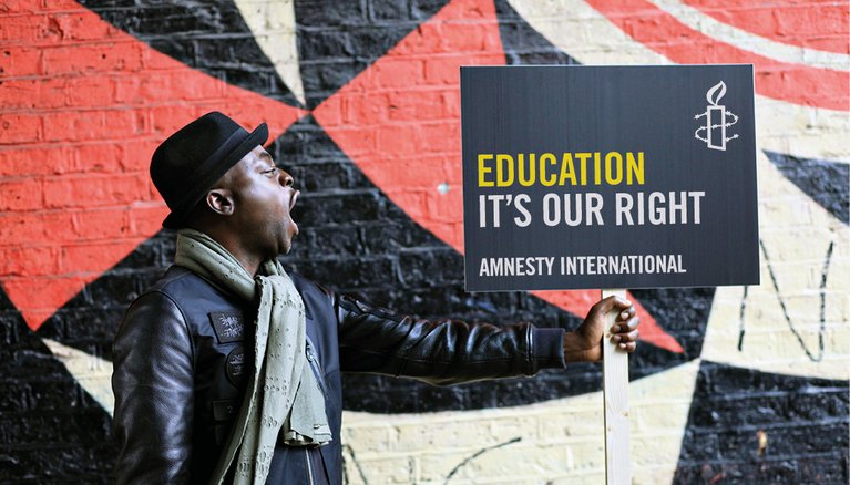 Person holding a placard that reads 'Education. It's Our Right'