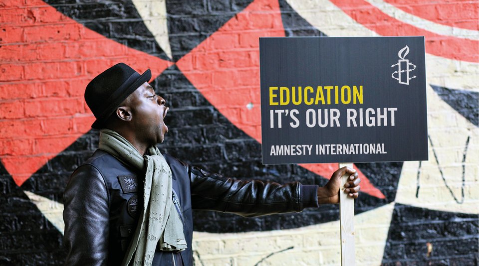 Person holding a placard that reads 'Education. It's Our Right'
