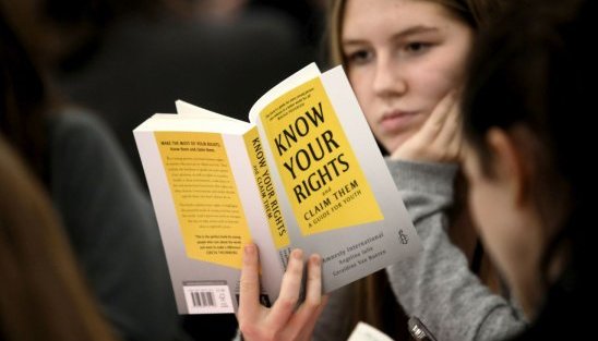 Person reading a book titled 'Know Your Rights'
