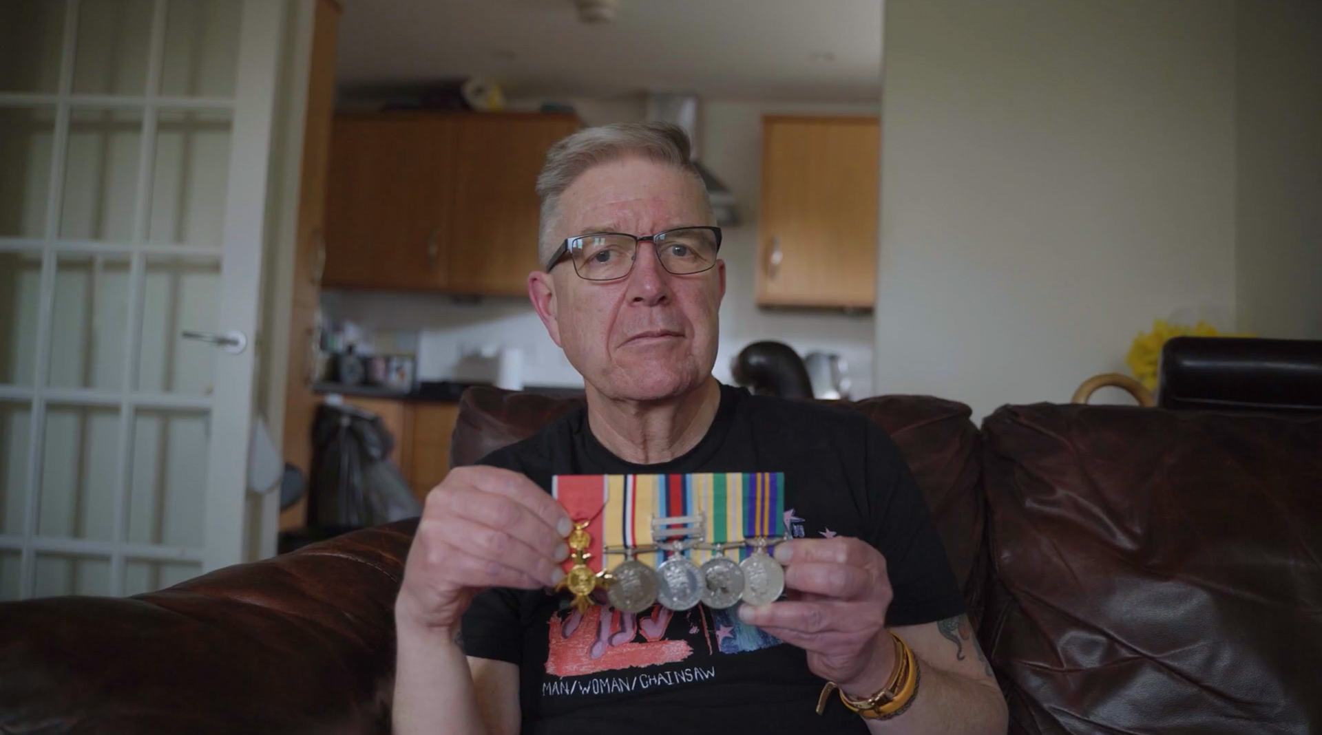 John, a person facing a difficult reality of PIP decisions, showing his military medals.
