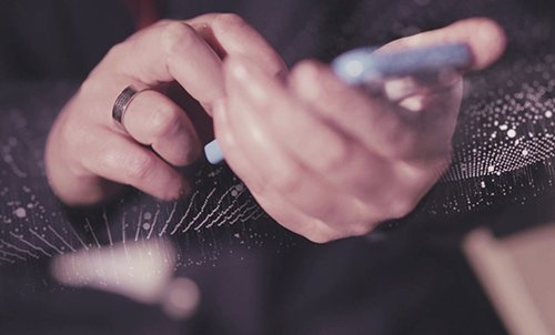 A close up picture of someone typing on their smartphone