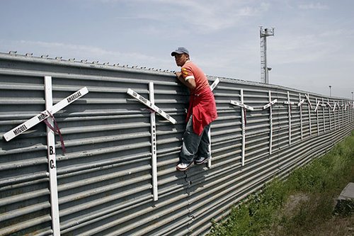 Migrant from Mexico into the US at the Tijuana-San Diego border. The crosses represent the deaths of failed attempts.