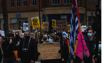 People protesting standing up for their right to do so. They hold placards and banners.