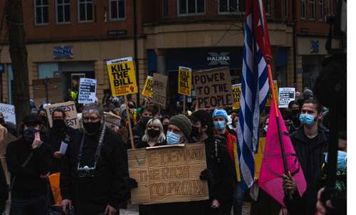 People protesting standing up for their right to do so. They hold placards and banners.
