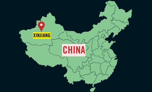 A cut out map of China, with a pin & label over Xinjiang in North-East China