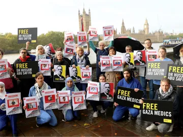 Medics wearing scrubs and activists holding placards reading “Free Gaza Medics”, “Free Dr Hussam Abu Safiya”, “Stop Arming Israel” the protesters stood against the backdrop of Parliament.