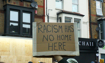 protest sign says racism has no home here