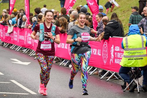 Image shows 2 people running in the Yorkshire Marathon.