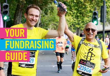 Two Amnesty supporters in Amnesty shirts holding hands up after completing a marathon event with title of 'Your Fundraising Guide'