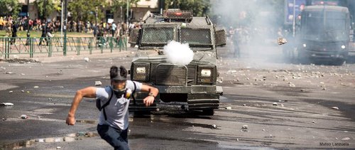 A protester runs away from security forces
