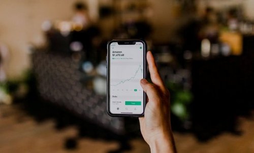 Image of someone looking at stocks and shares on their mobile phone.