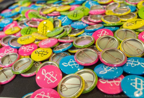 colourful badges with amnesty candle logo