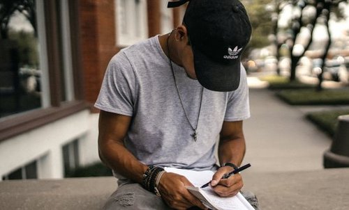 A man sitting down and handwriting a letter