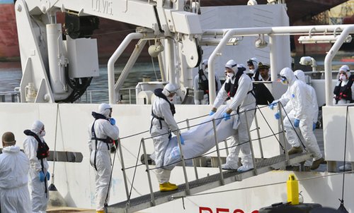Crew from an Italian Coast Guard ship disembark one of the estimated 700 victms