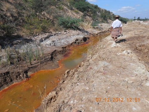 reddish-orange water in drainage channel near mines