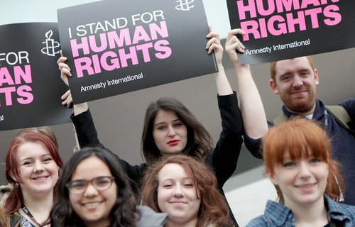 Activists hold placards saying 'I stand for human rights'