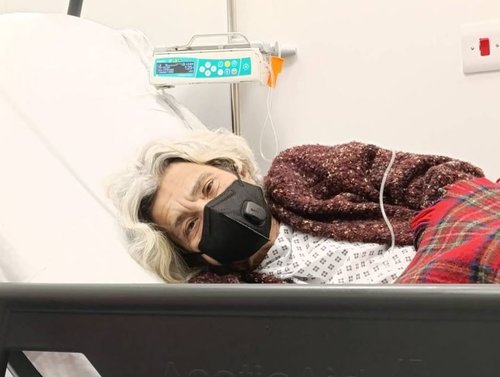 Laila is pictured lying in a hospital bed with a mask and attached to a drip