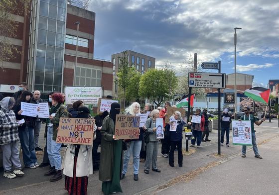 People standing outside holding placards opposing the company Palantir in our NHS