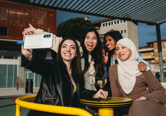 Four happy teens taking a selfie outdoors