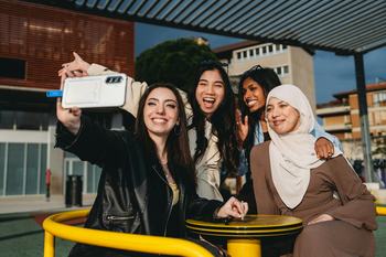 Four happy teens taking a selfie outdoors